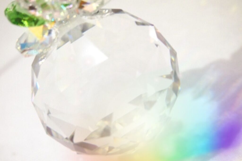 透明なクリスタルに虹の光が散るサンキャッチャーのアップ