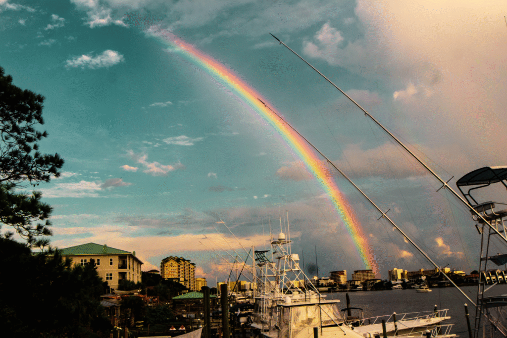 青空にかかる虹と重なるように輝くサンキャッチャーの光