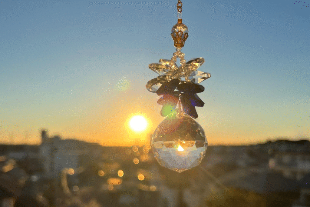 夕暮れの光を受けて静かに輝くサンキャッチャー。あたたかな虹のプリズムが部屋に広がる